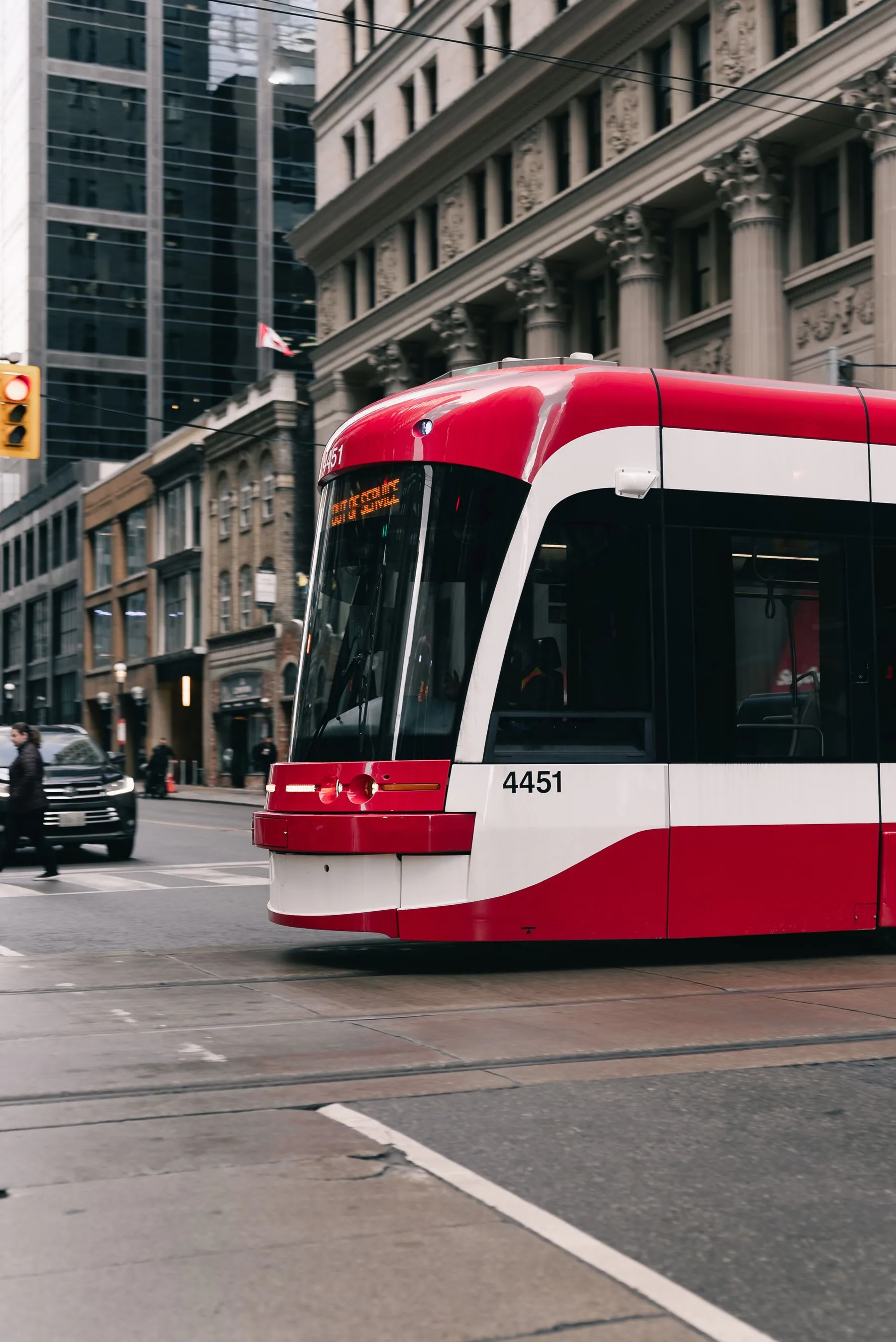 A red TTC streetcar on a downtown Toronto street